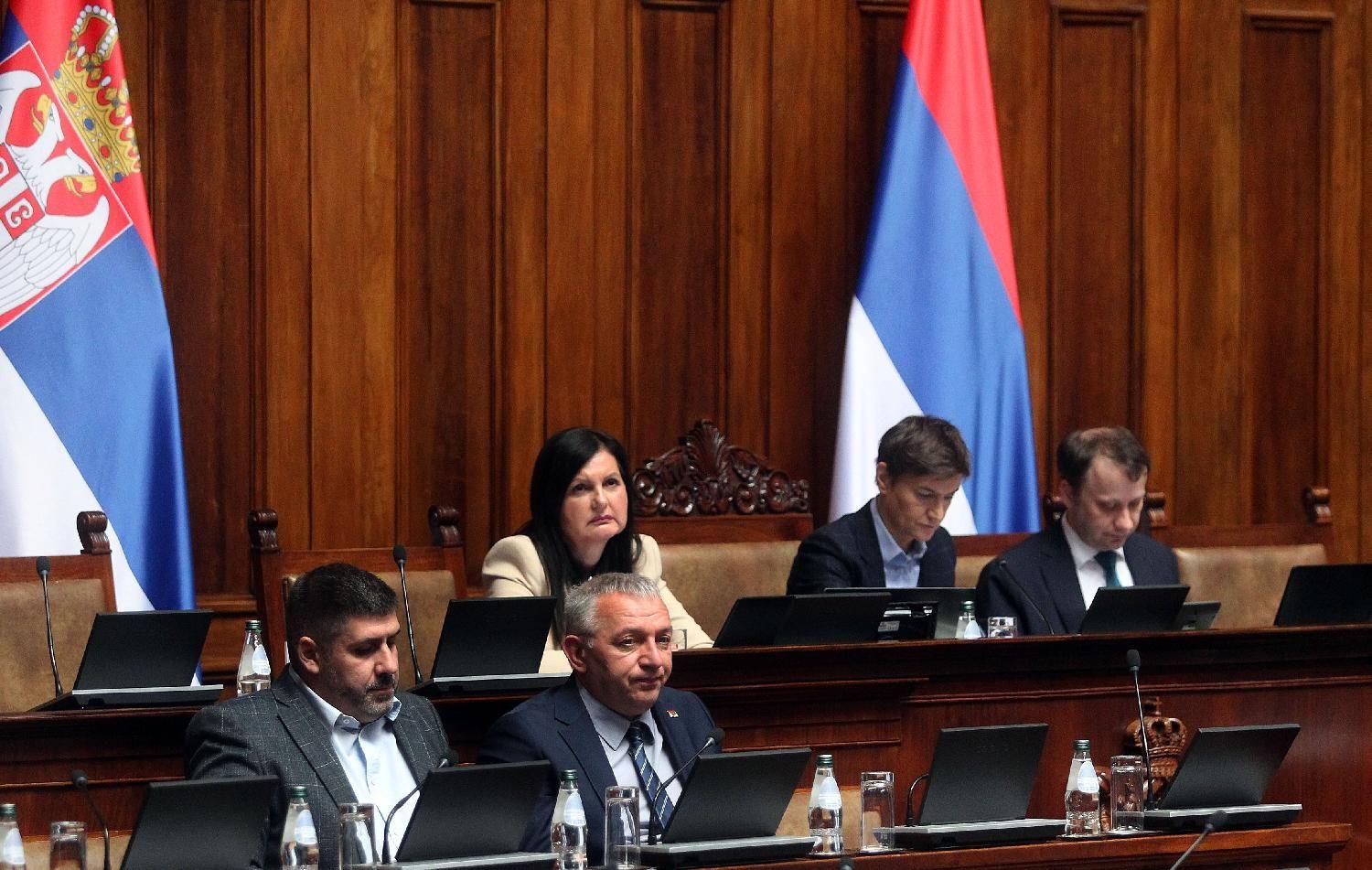 Petoro poslanika u skupštini, iza njih je zastava Srbije