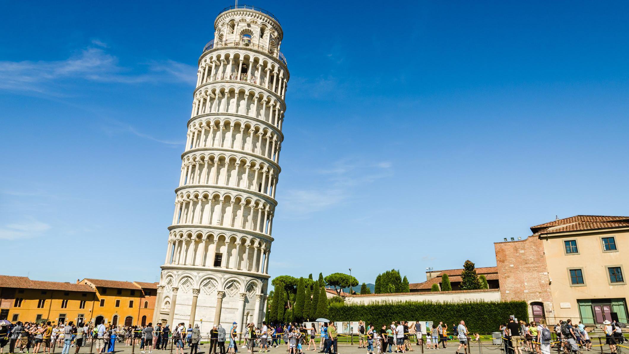 A Torre Inclinada de Pisa em um dia ensolarado com multid&otilde;es aos p&eacute;s.