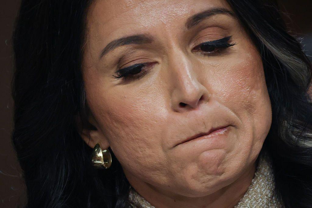 Tulsi Gabbard, en primer plano, se muerde un labio. 
