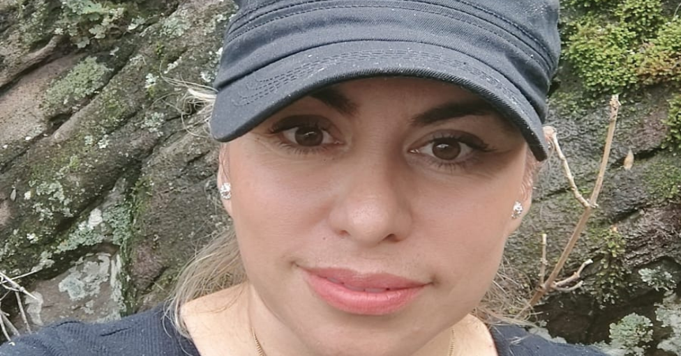 Yadira González, de boné, olha para a câmera em frente a uma árvore