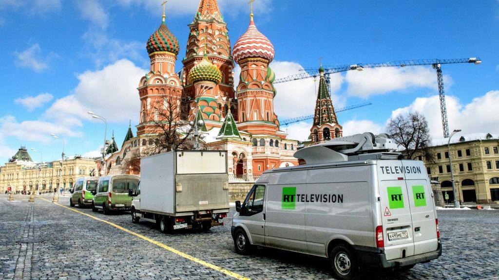 Van da TV estatal russa RT estacionada em frente à Catedral de São Basílio e ao Kremlin, em Moscou 