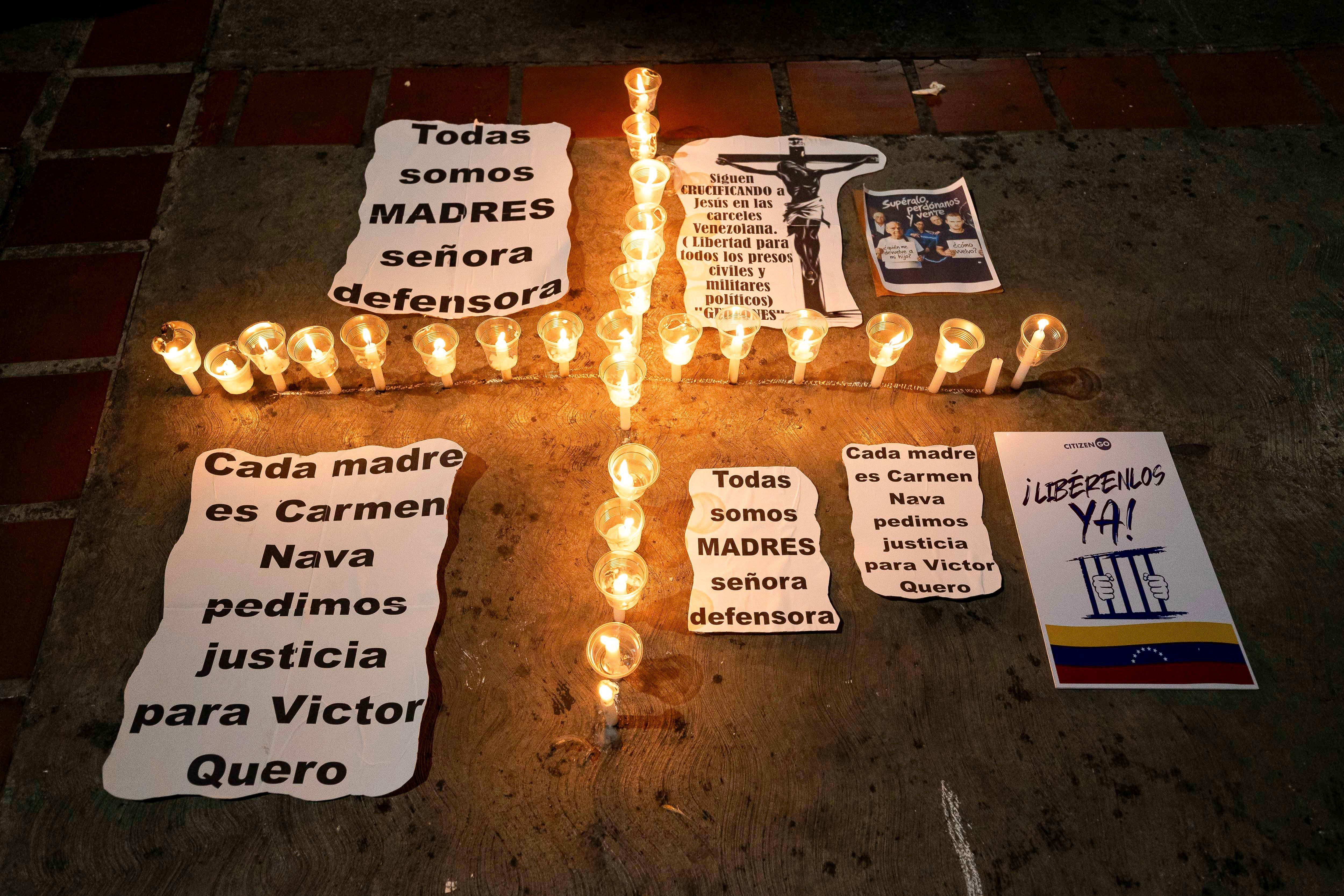 Mensajes de apoyo durante una vigilia organizada por familiares de presos en memoria del fallecido Víctor Hugo Quero y en solidaridad con su madre y con críticas a la Defensora del Pueblo. En los carteles se puede leer "Cada madre es Carmen Nava, pedimos justicia para Víctor Quero", "Todas somos madres, señora defensora". Los cartles rodean a una cruz hecha con pequeñas velas. En otro cartel se lee "Libérenlos ya, con la bandera de Venezuela". 