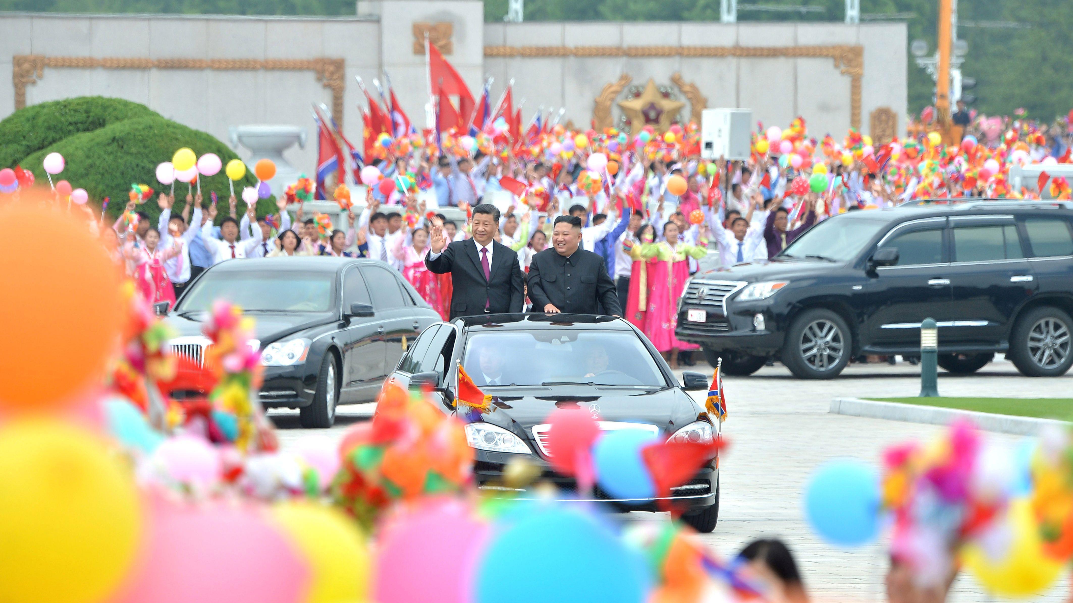 'Kovano u krvi': Odnos Kine i Severne Koreje između ljubavi i mržnje 2 Severnokorejski lider Kim Džong Un i kineski predsednik Si Đinping stoje u povorci i mašu gomili ispred Međunarodnog aerodroma Pjongjang u Severnoj Koreji 21. juna 2019. godine