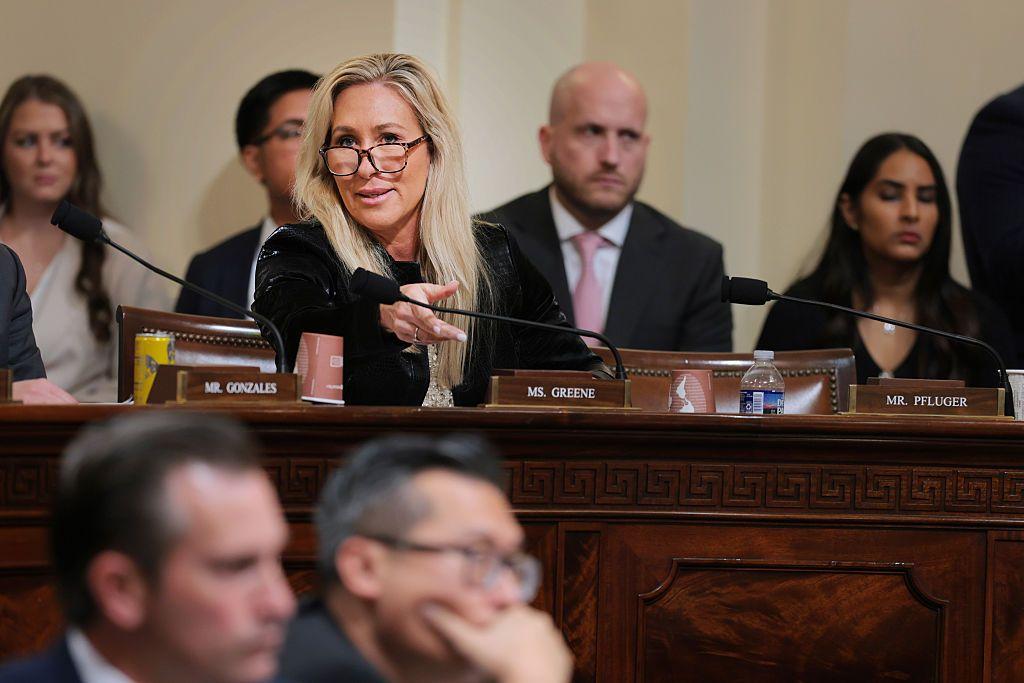 Marjorie Taulor Greene en su asiento del Congreso, rodeada de otros representantes.