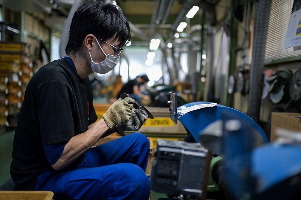 Trabajador japonés en una fábrica en Seki, Japón.