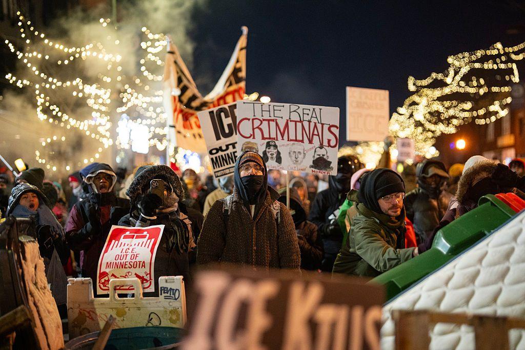 Manifestantes durante una vigilia por la muerte del enfermero Alex Pretti portando carteles en el que se acusa al ICE de 
