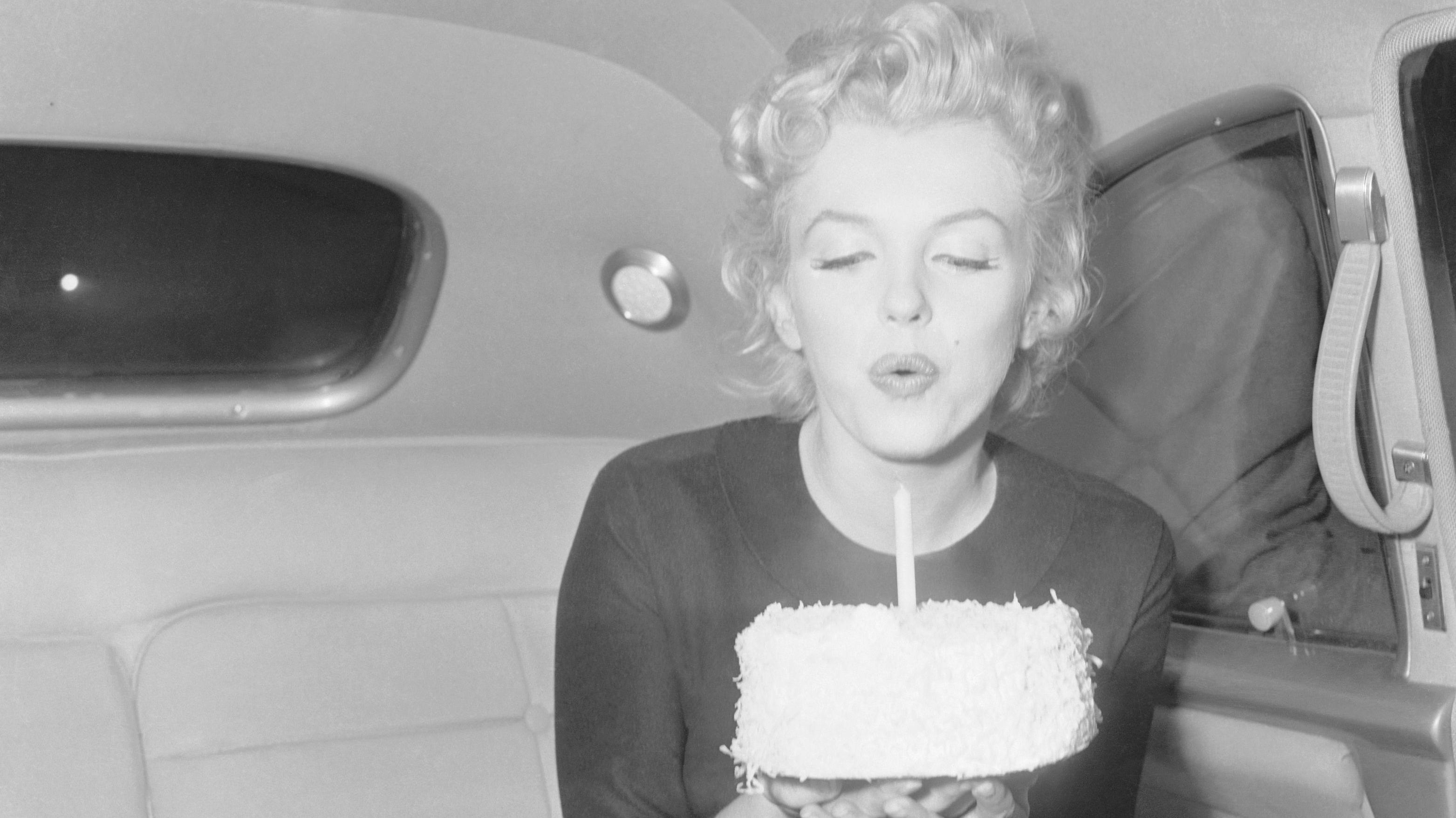 Marilyn Monroe sopla la vela de una tarta el 1 de junio de 1956