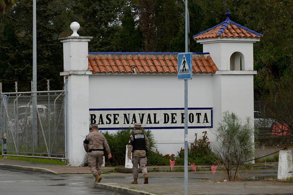 Dos militares caminan frente a la entrada a la Base Naval de Rota