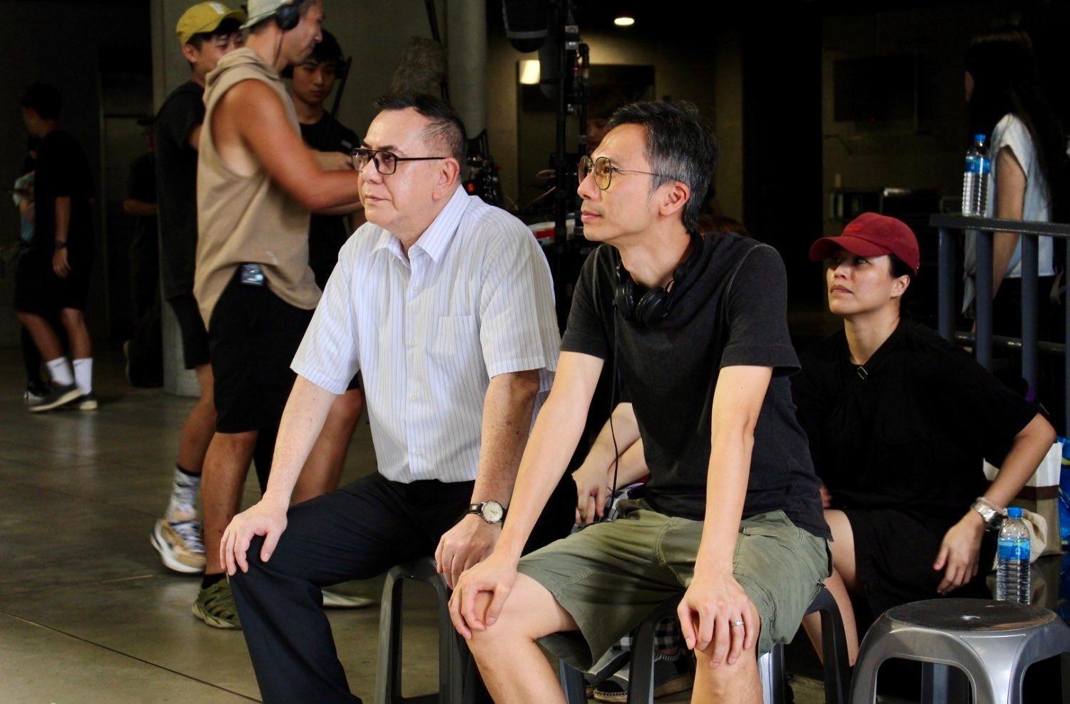 周冠威（右二）與黃秋生（右三）身處片場中，身後有幾名拍攝工作人員。