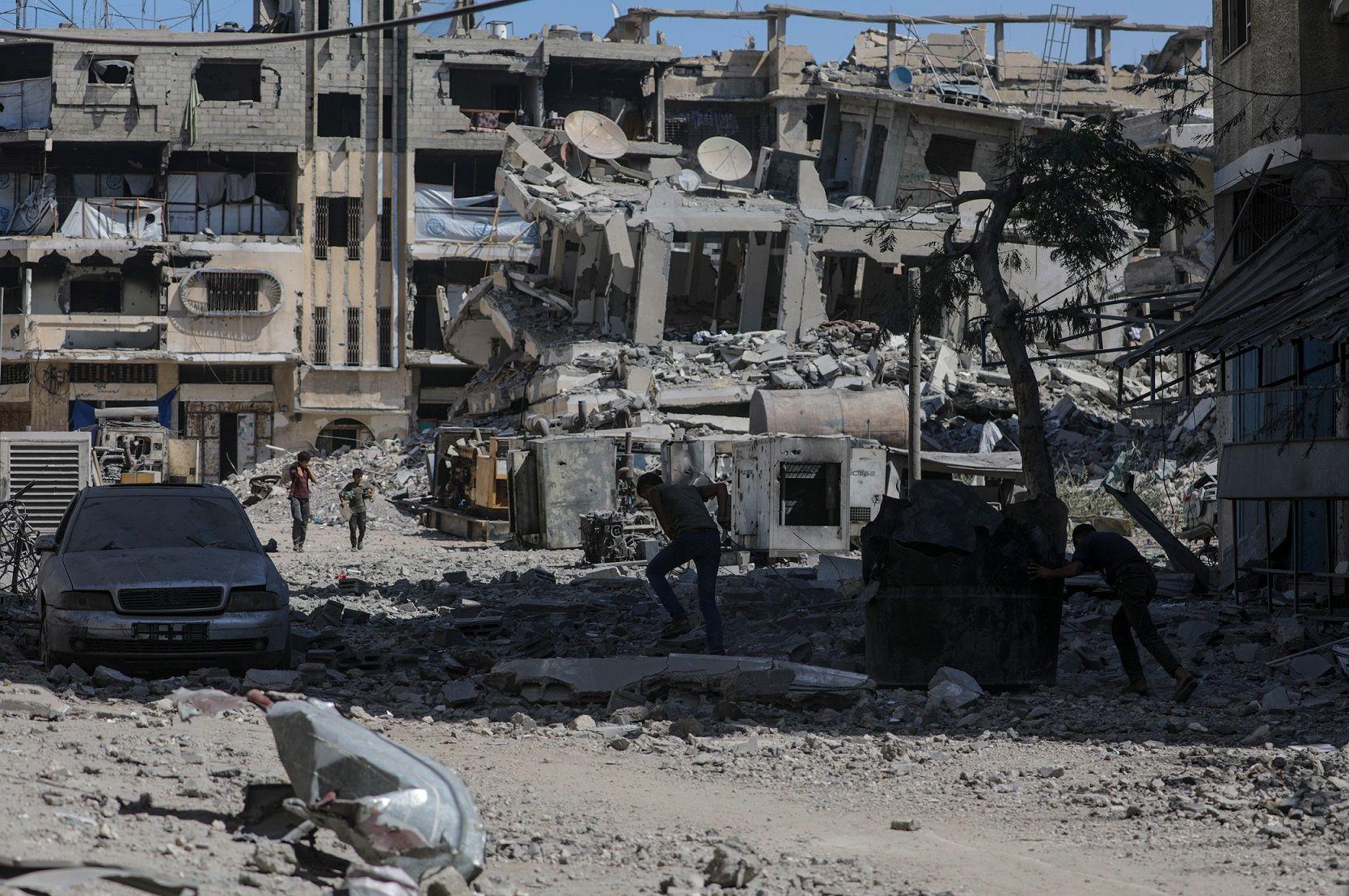 Palestinos andam em área destruída após ataques aéreos de Israel na Cidade de Gaza, no dia 30 de setembro de 2025. 