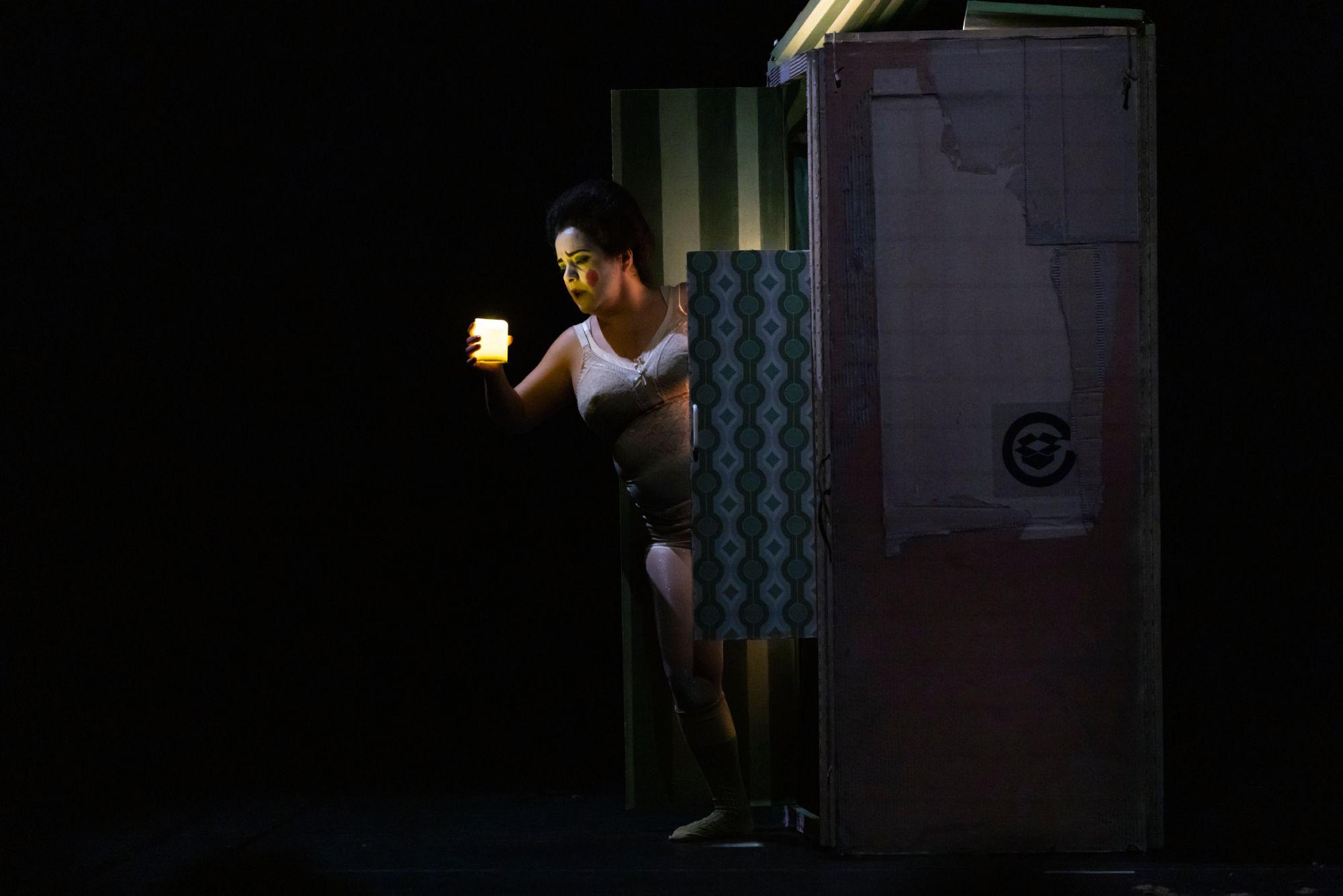 El personaje de Chula, vestida en ropa interior, sostiene una vela encendida