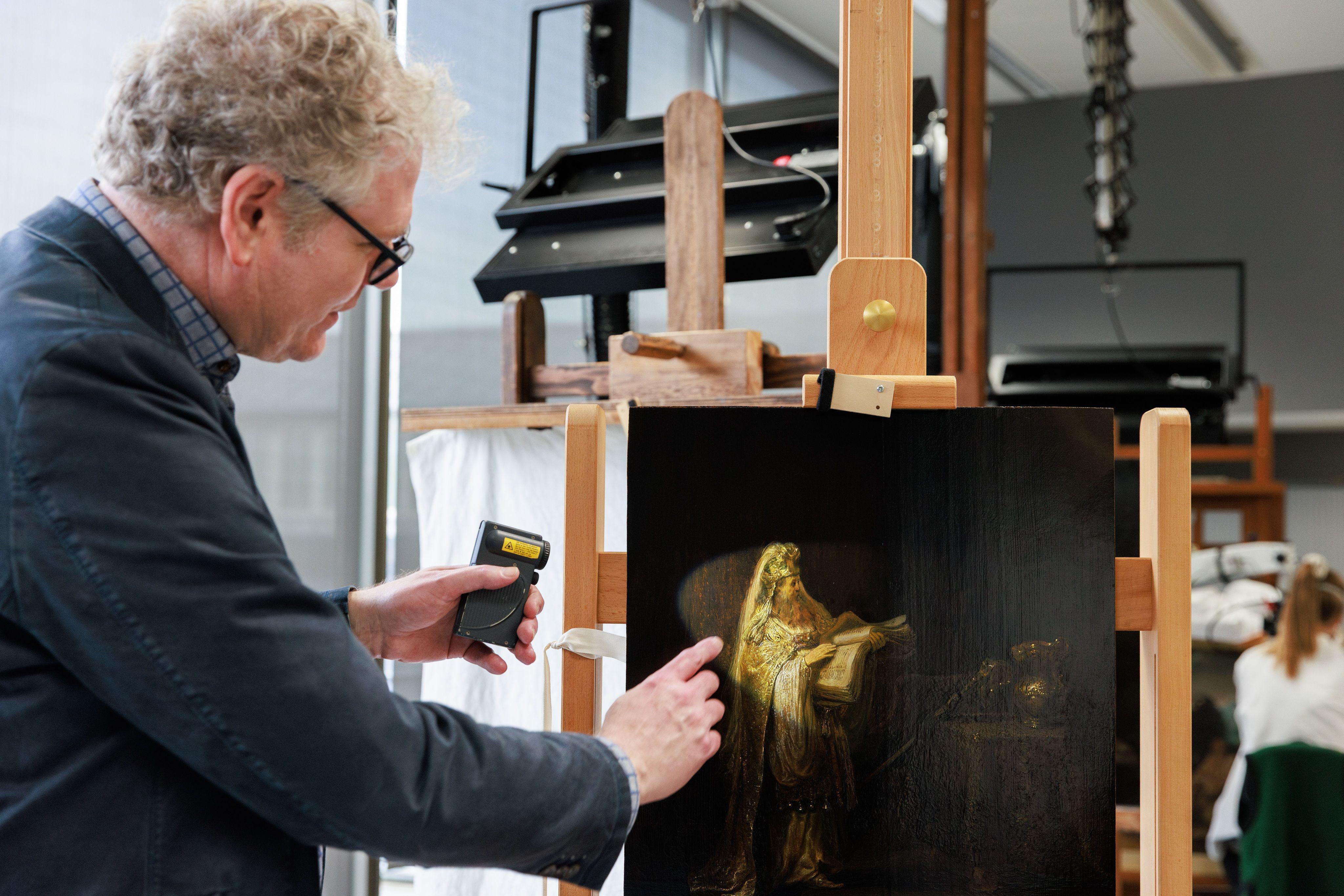 Istraživač pokazuje na figuru Zaharije sa Rembrantove slike(1633), koja se nalazi na štafelaju, i usmerava je svetlom