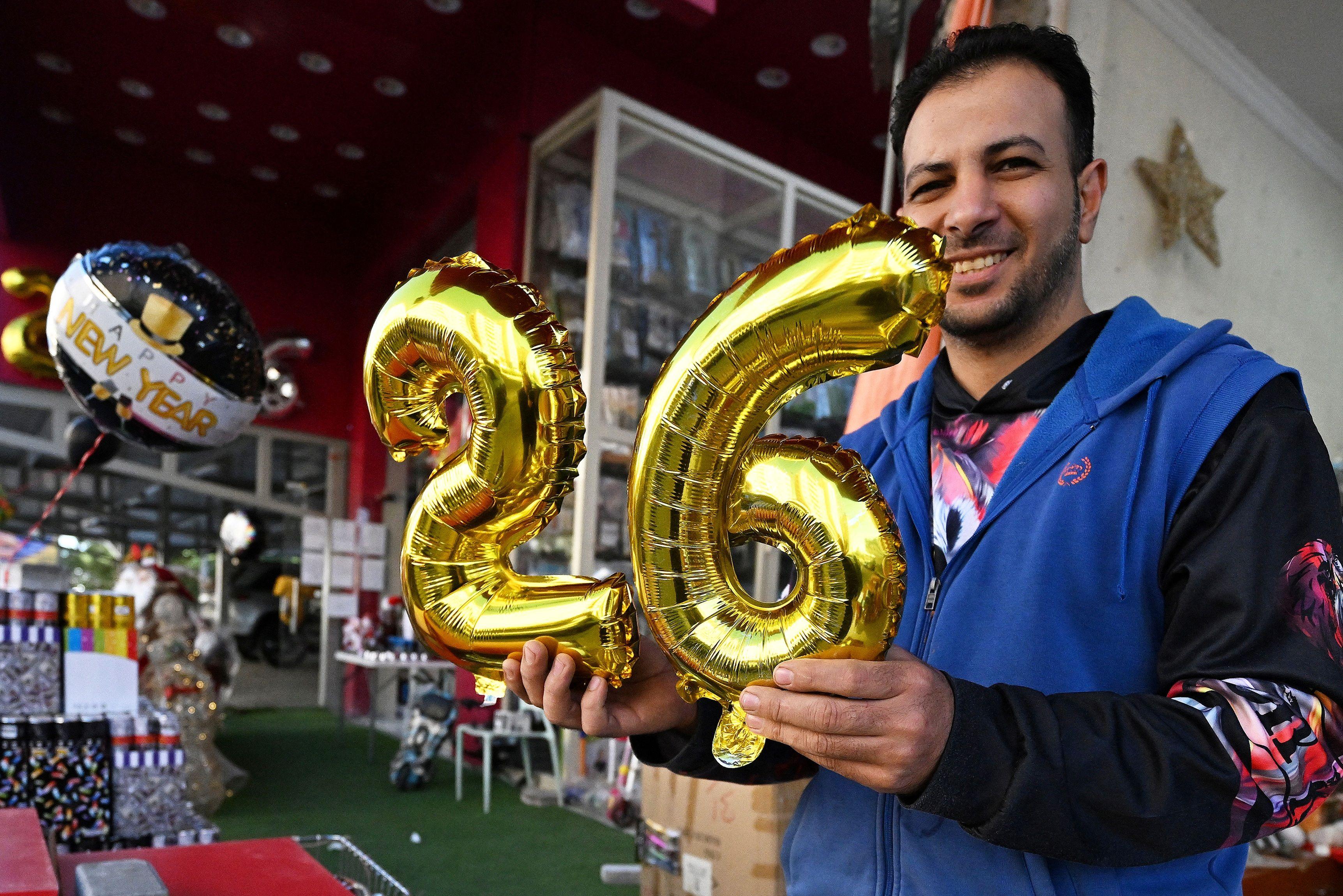 بائع يحمل بالونات بالرقم 26 في إشارة إلى العام الجديد في العاصمة الكويت