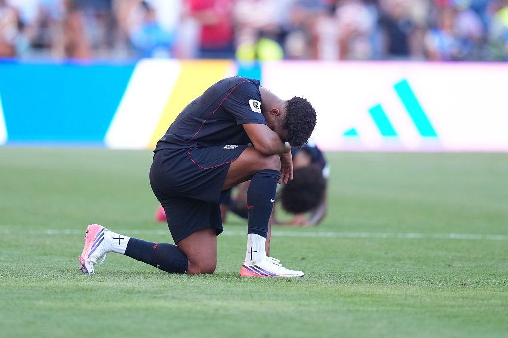 Jugador estadounindese de rodillas después de la derrota frente a Belgica.