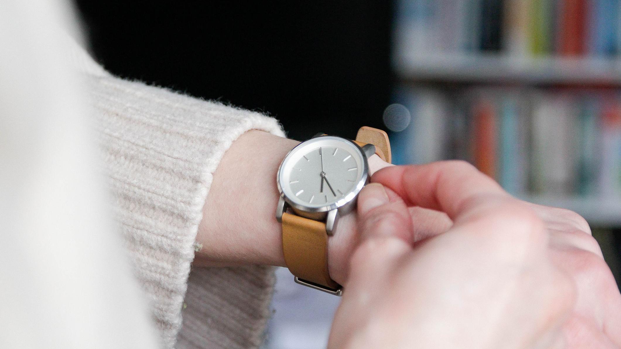 شخص يغير توقيت ساعة يد