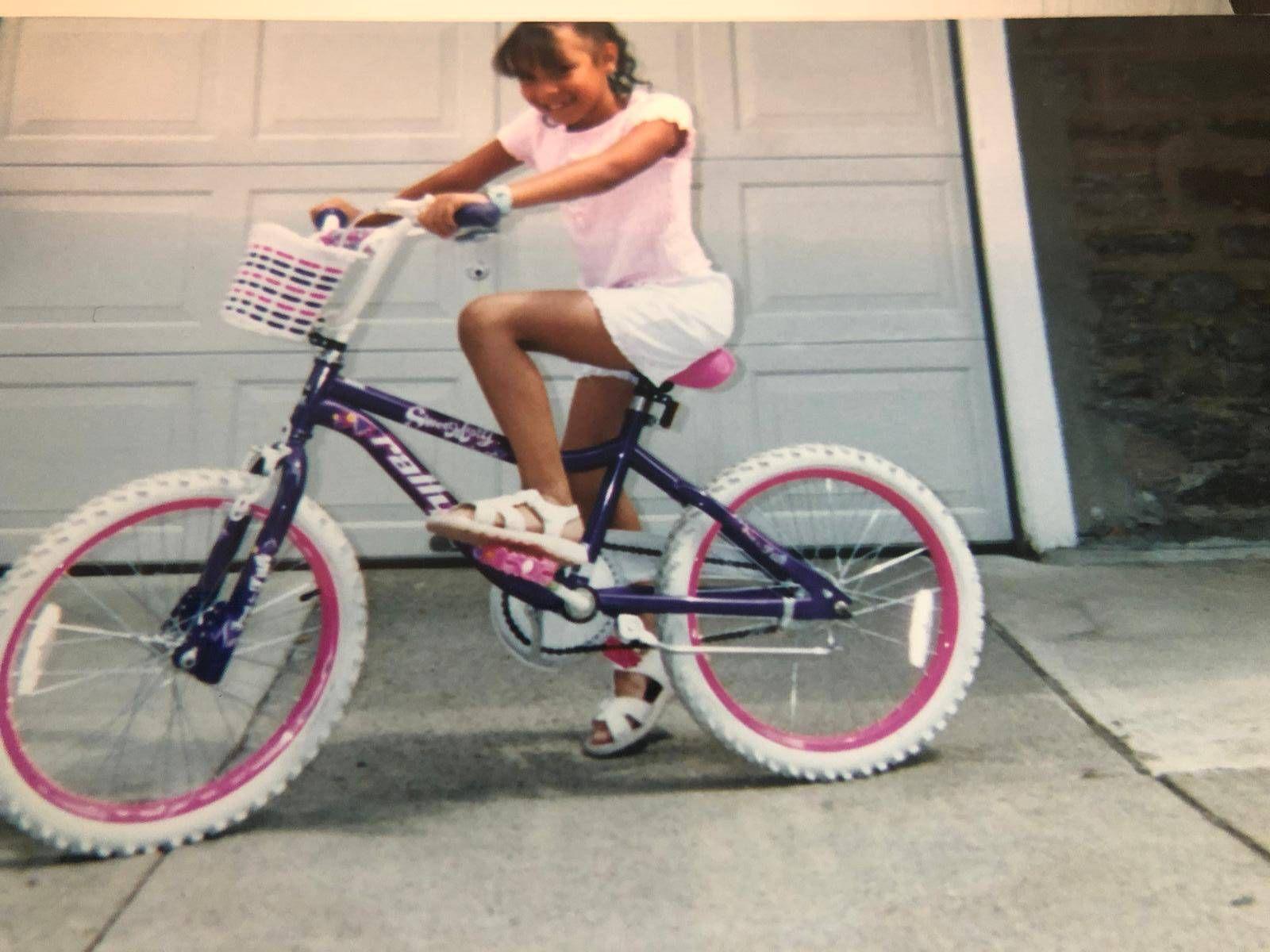Delimar Vera montando una bicicleta cuando era una niña.