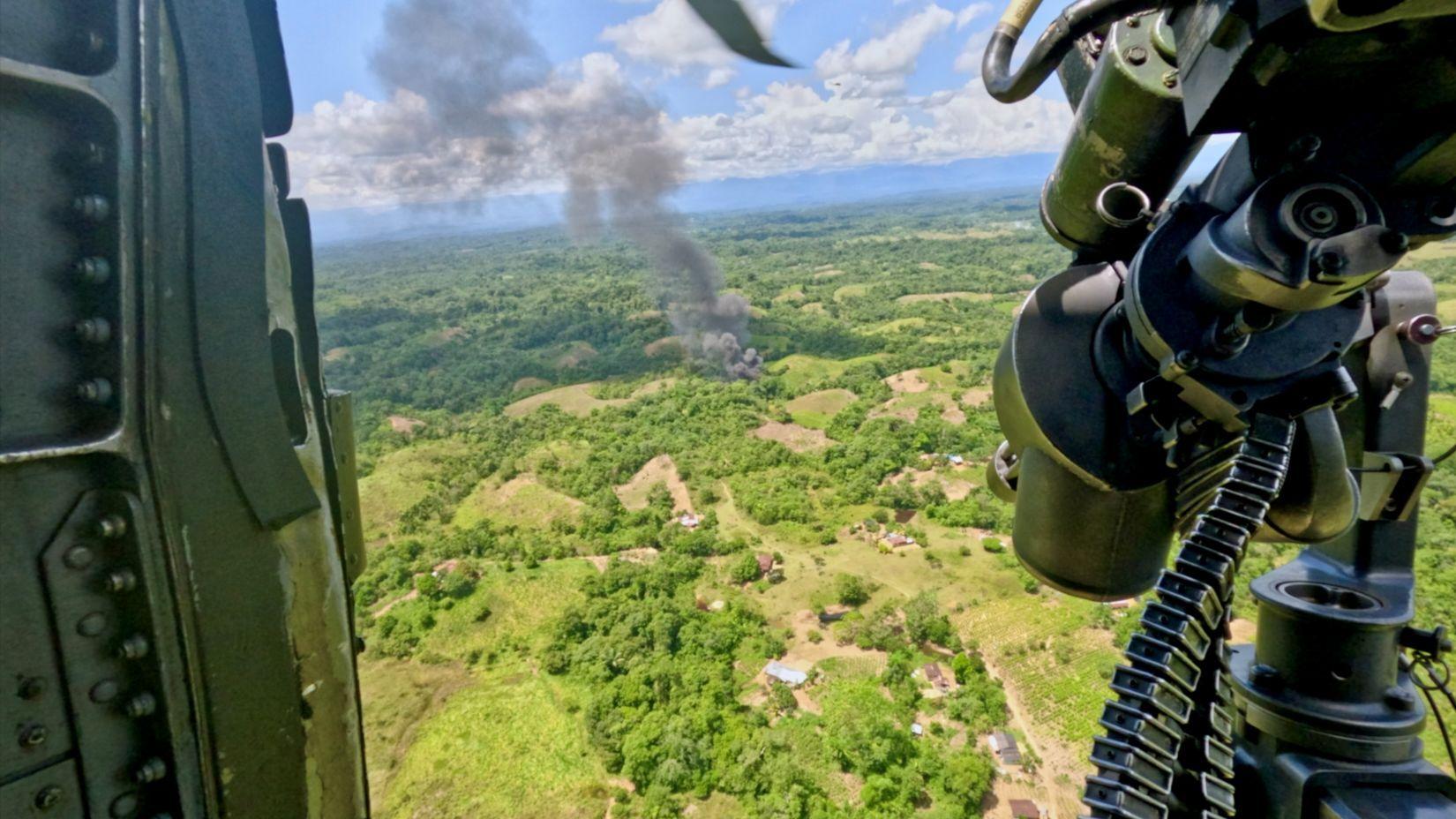 Se ve humo elevándose en la distancia después de que los comandos incendiaran un laboratorio de cocaína. La fotografía fue tomada desde la puerta abierta de un helicóptero.