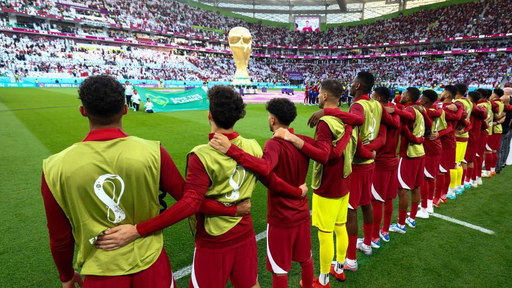 فريق منتخب قطر لكرة القدم باللون العنابي في مباراة كأس العالم 2022 ضد السنغال، صورة لتشكيلة اللاعبين من الخلف.
