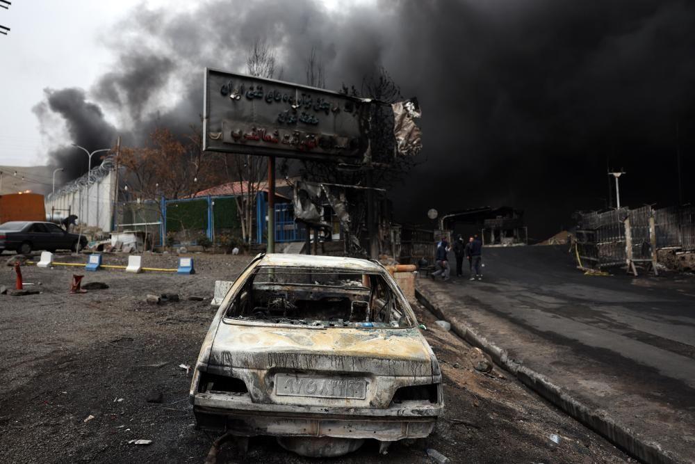 Um carro carbonizado permanece em meio &agrave; destrui&ccedil;&atilde;o ap&oacute;s um ataque com m&iacute;ssil ao dep&oacute;sito de petr&oacute;leo de Shahran, em Teer&atilde; (08/03/2026)