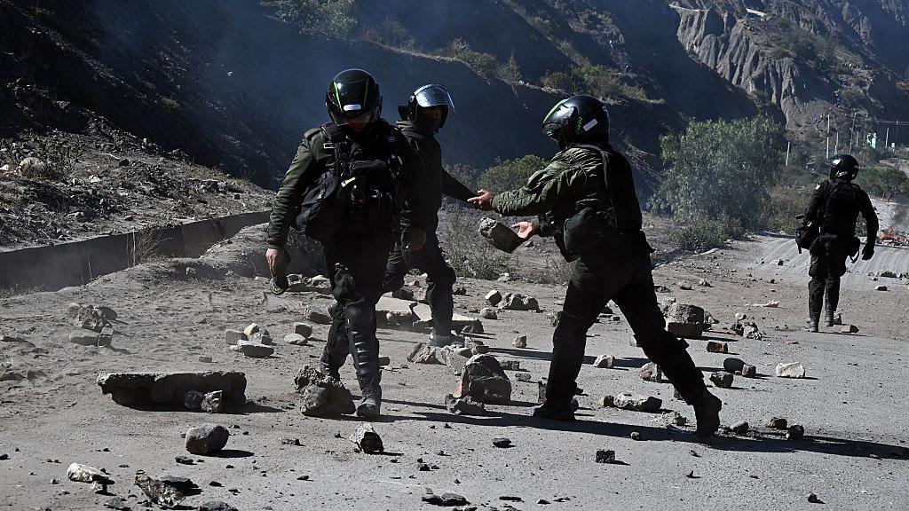 Agentes antidisturbios retiran piedras de una carretera bloqueada por manifestantes rurales en Lipari, departamento de La Paz, Bolivia, el 16 de mayo de 2026.