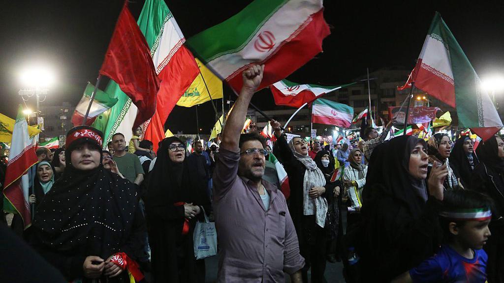 تجمع مواطنون يحملون أعلام إيران وحزب الله في ساحة "انقلاب" في طهران، إيران، لتنظيم مظاهرة دعماً للحكومة في أعقاب الهجوم الصاروخي الإيراني على إسرائيل، في 8 يونيو/ حزيران 2026.
