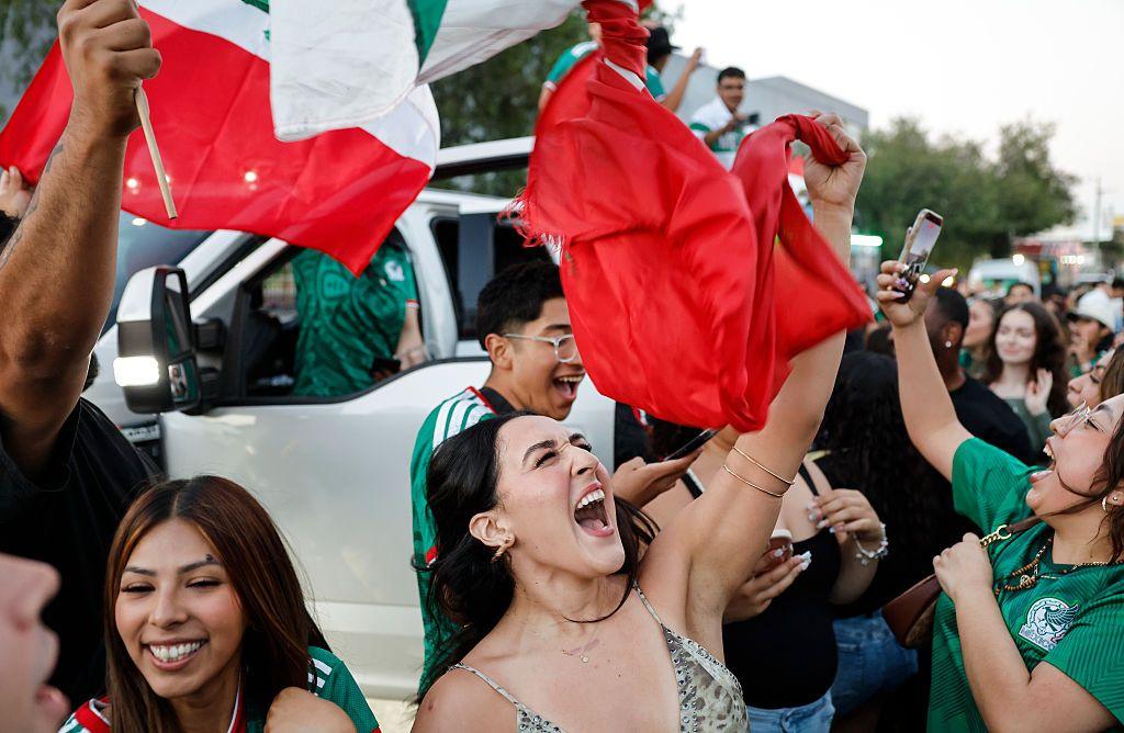 Mexicanos con la bandera celebran el triunfo de su selección. 