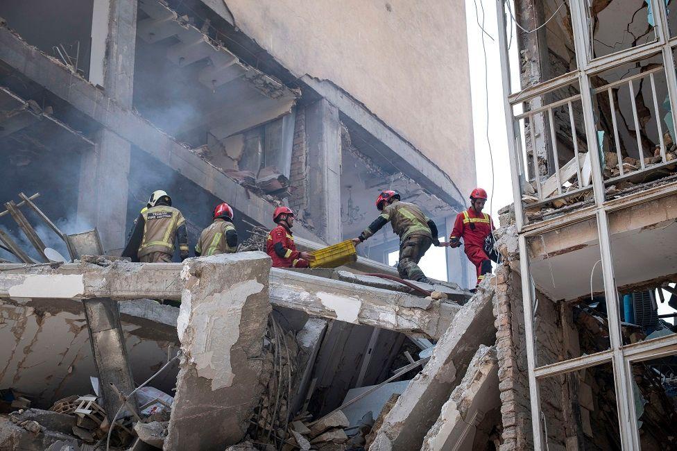 Bomberos en un edificio destruido