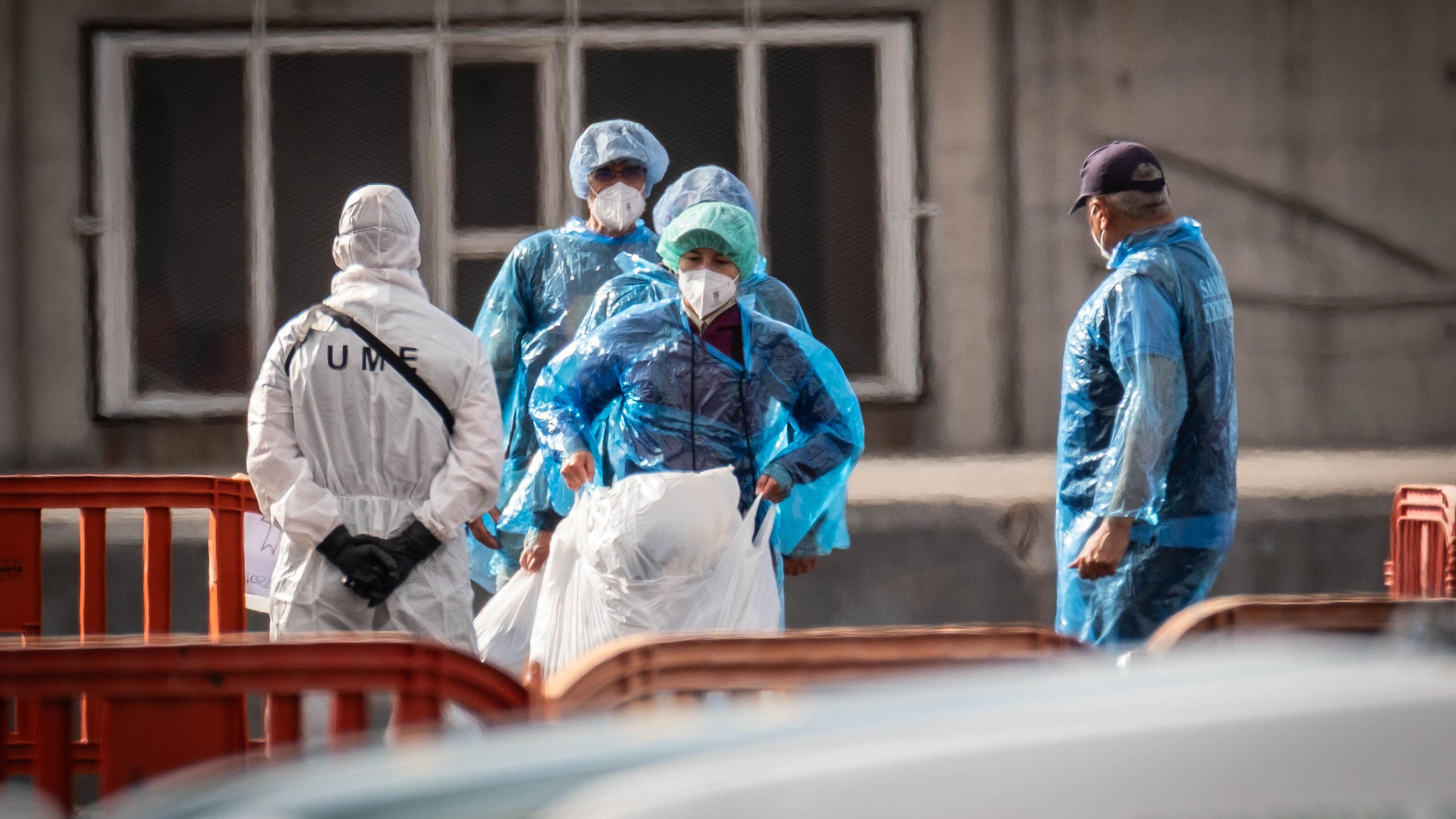 Passengers evacuated from the cruise ship wear masks and protection on their clothing to avoid contagion. 