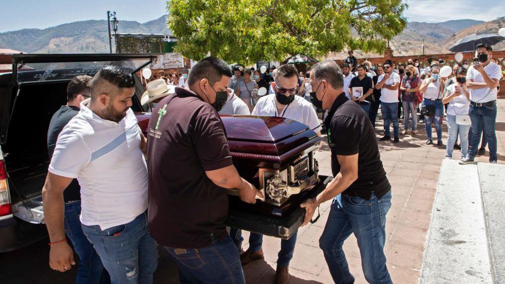 Hombres cargan el ataúd con los restos del alcalde César Arturo Valencia en su funeral en Aguililla, estado de Michoacán, en marzo de 2022.