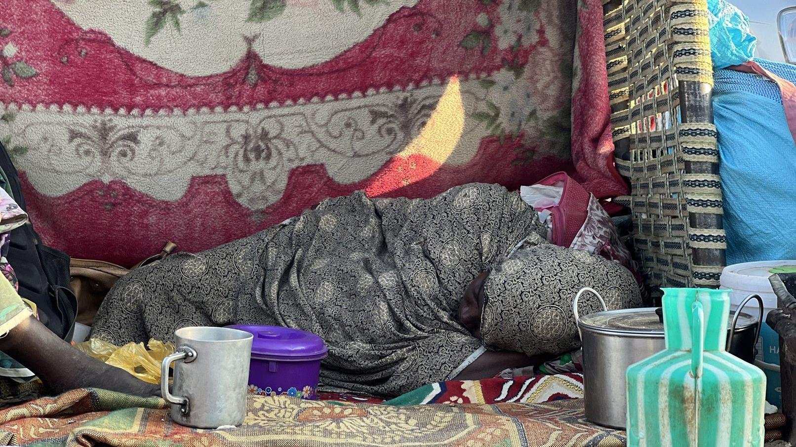 نزح أكثر من 62 ألف شخص إثر سيطرة قوات الدعم السريع على مدينة الفاشر، عاصمة ولاية شمال دارفور السودانية، في 1 نوفمبر/تشرين الثاني 2025. وتهر سيدة مستلقية على الأرض أمامها وعء للطبخ وآخر للشرب.