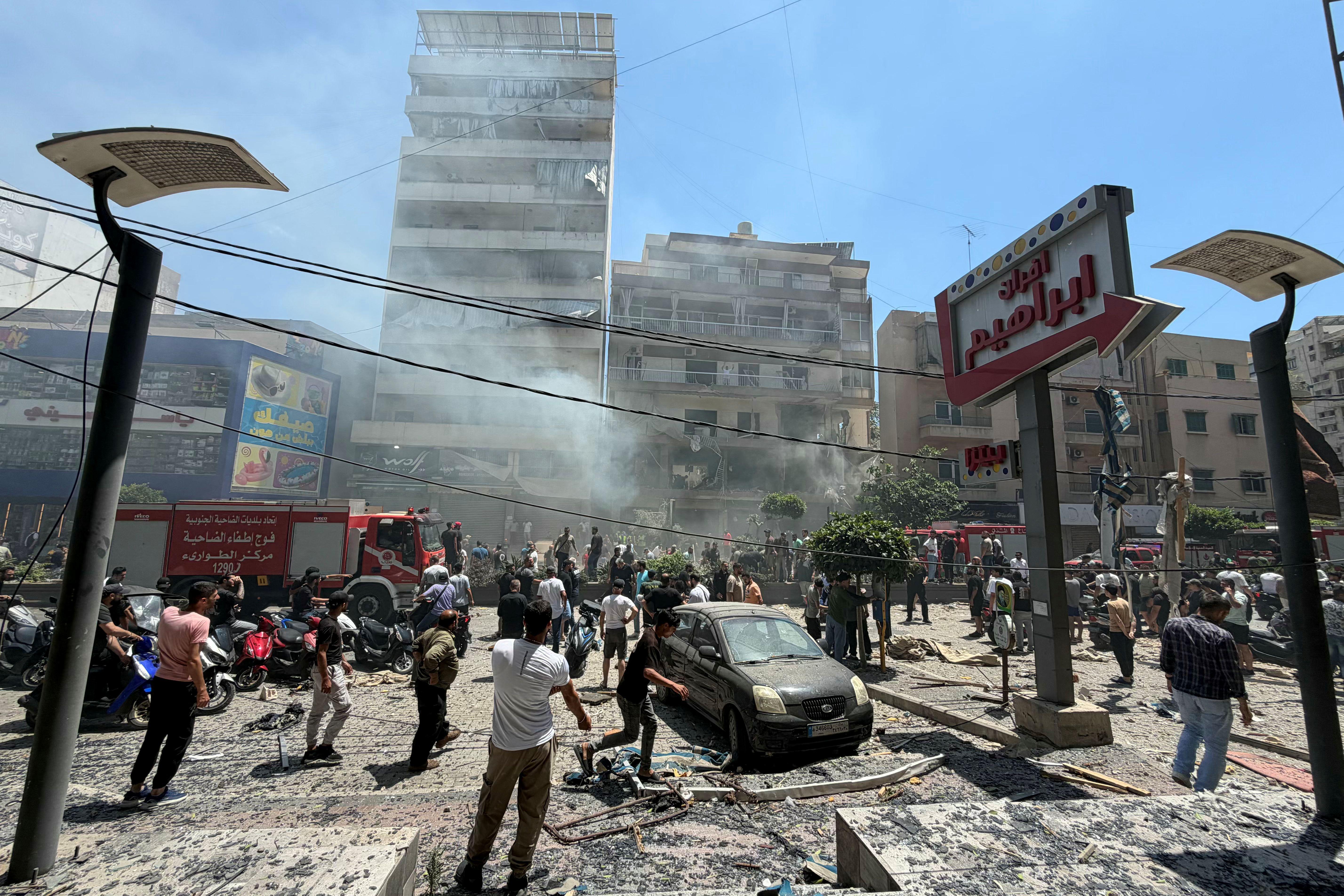 تجمع أشخاص في موقع ضربة إسرائيلية استهدفت مبنى في الضاحية الجنوبية لبيروت، في وقت لا يزال فيه انعكاس الاتفاق الأمريكي الإيراني على جبهة لبنان غير واضح.