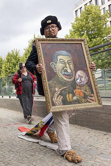 El artista Semyon Skrepetsky camina con uno de sus cuadros 