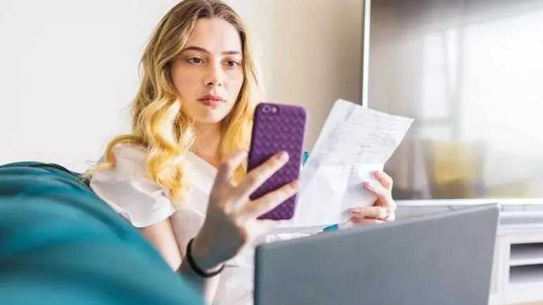 امراة تمسك بهاتف