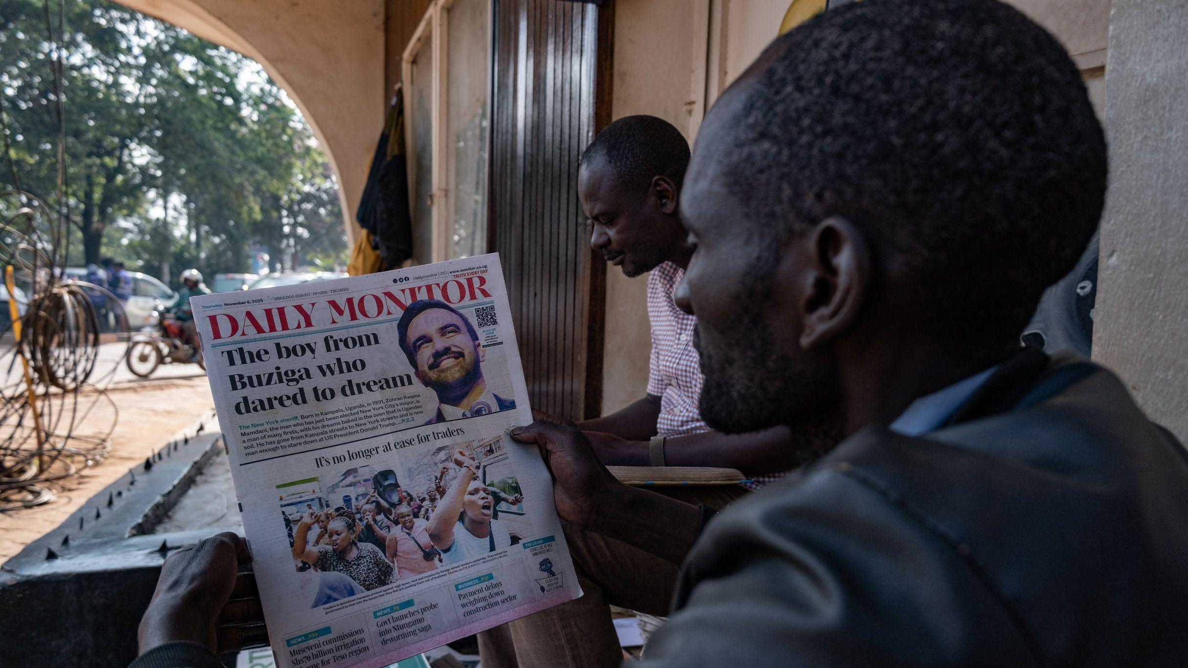 يقرأ أحد السكان صحيفةً تحمل عناوين رئيسية حول فوز زهرة ممداني، المولود في أوغندا، عمدة مدينة نيويورك المنتخب، في كامبالا، في 6 نوفمبر/تشرين الثاني 2025.
