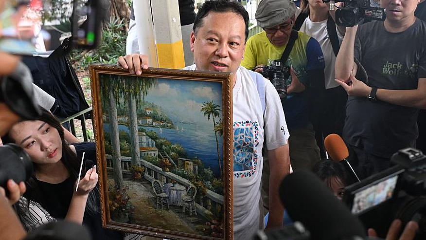 宏新閣居民鍾先生向在場傳媒展示從家中執拾出來的畫作