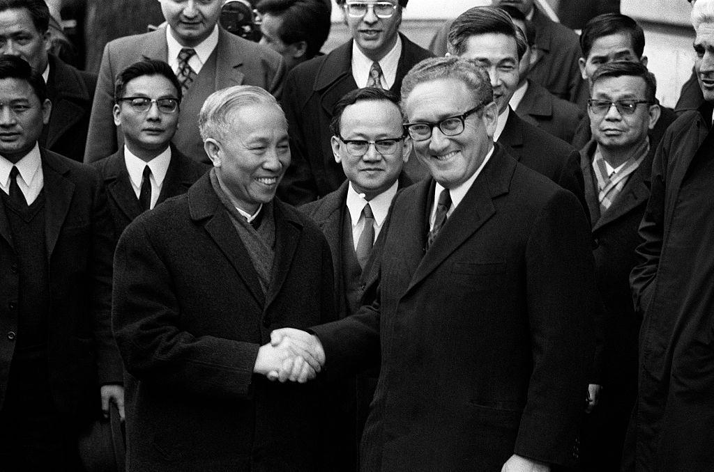 Le Duc Tho y Henry Kissinger se dan la mano frente a las cámaras en 1973