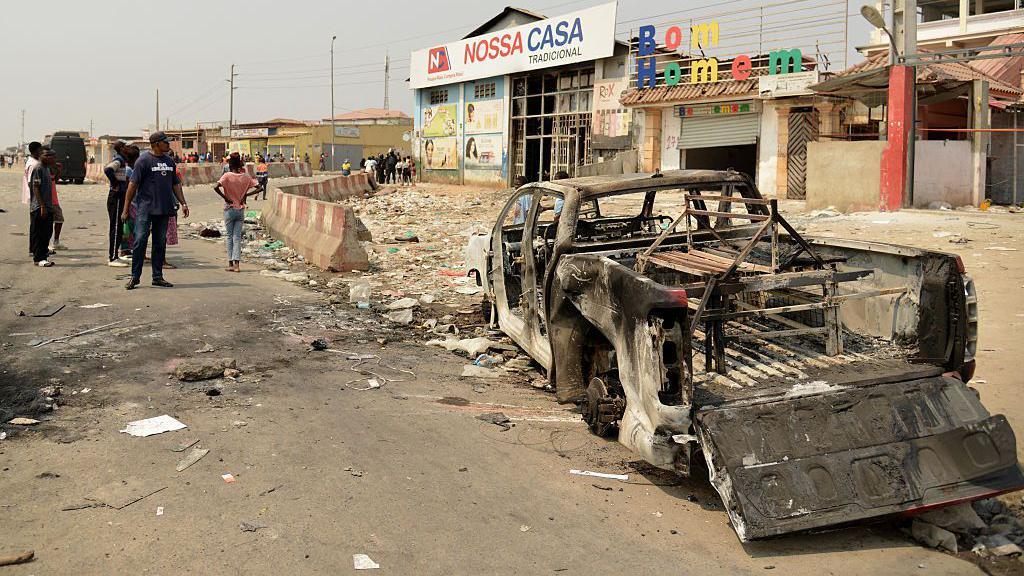 Um caminh&atilde;o queimado em uma rua de Luanda, capital da Angola