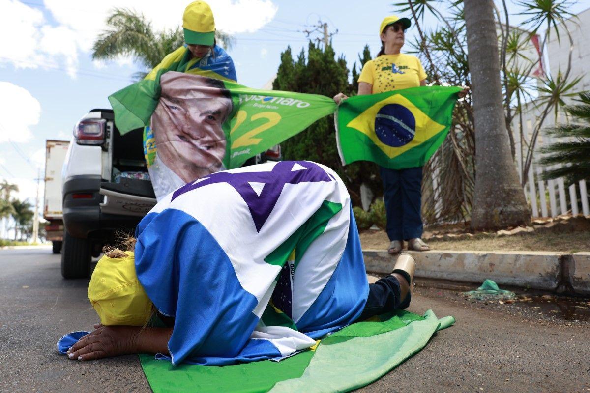 Apoiadores de Bolsonaro orando em rua