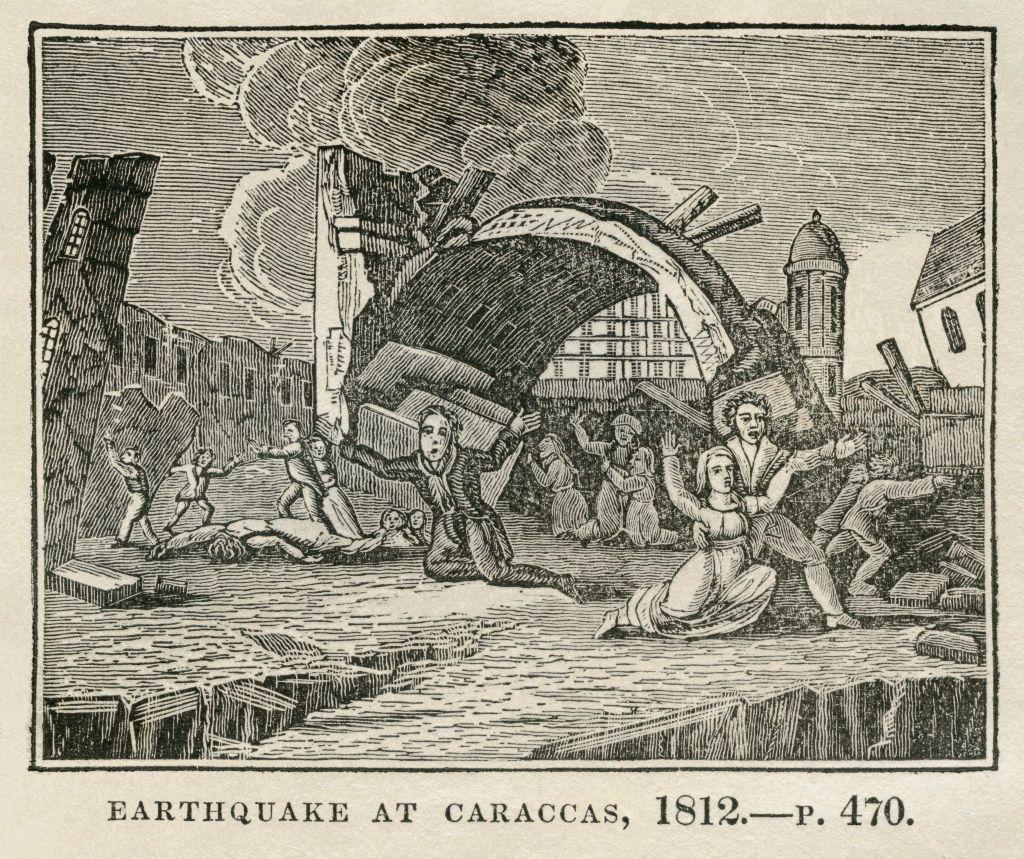 Un grabado de época muestra un grupo de personas arrodilladas y con los brazos en cruz y otras en aparente desesperación rodeados de edificaciones destruidas. Un mensaje al pie dice en inglés: Terremoto en Caracas, 1812.