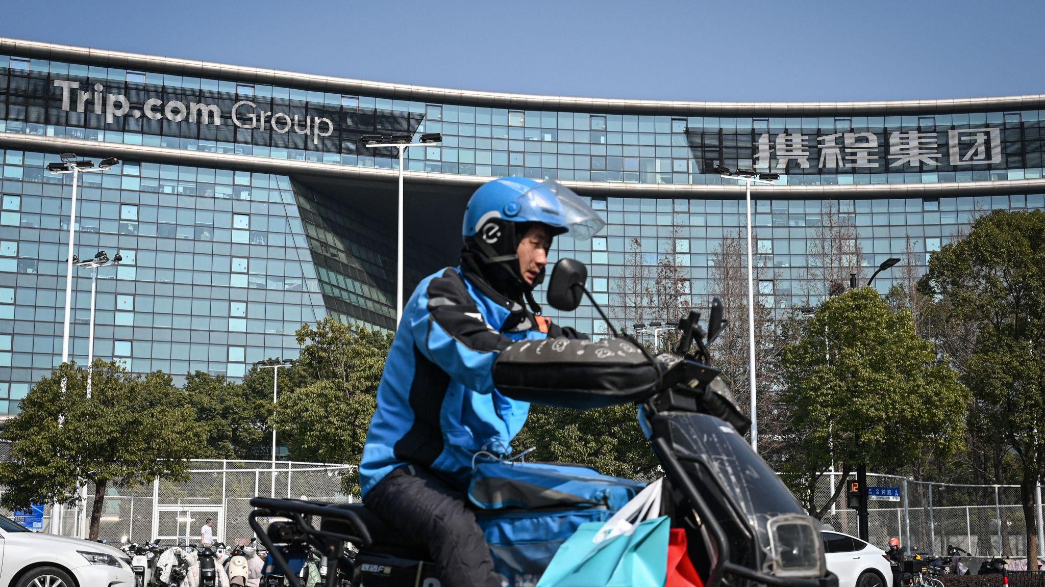 一位外賣小哥騎著摩托車駛過上海攜程集團總部門外（15/1/2026）