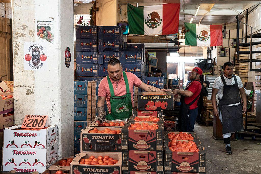 Hombre vendiendo tomates en el mercado. 