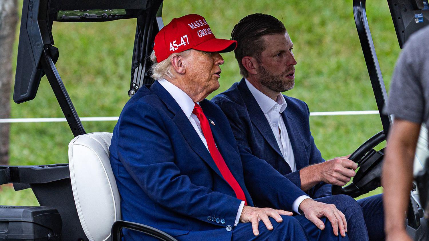 Donald Trump y su hijo Eric Trump en un carrito de golf en el Trump National Doral Miami, el 3 de abril de 2025 en Doral, Florida. 