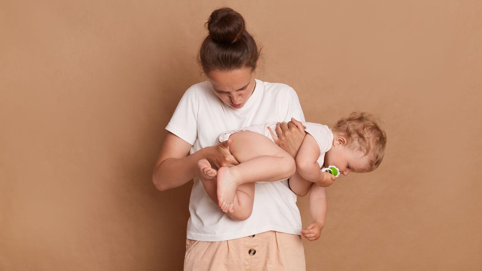 Una madre inspecciona el pañal de su bebé