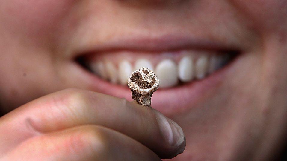 Indiv&iacute;duo segura um dente com a m&atilde;o