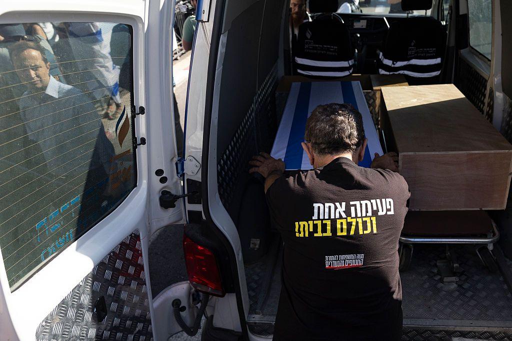 Homem inclinado sobre caixão com bandeira de Israel 