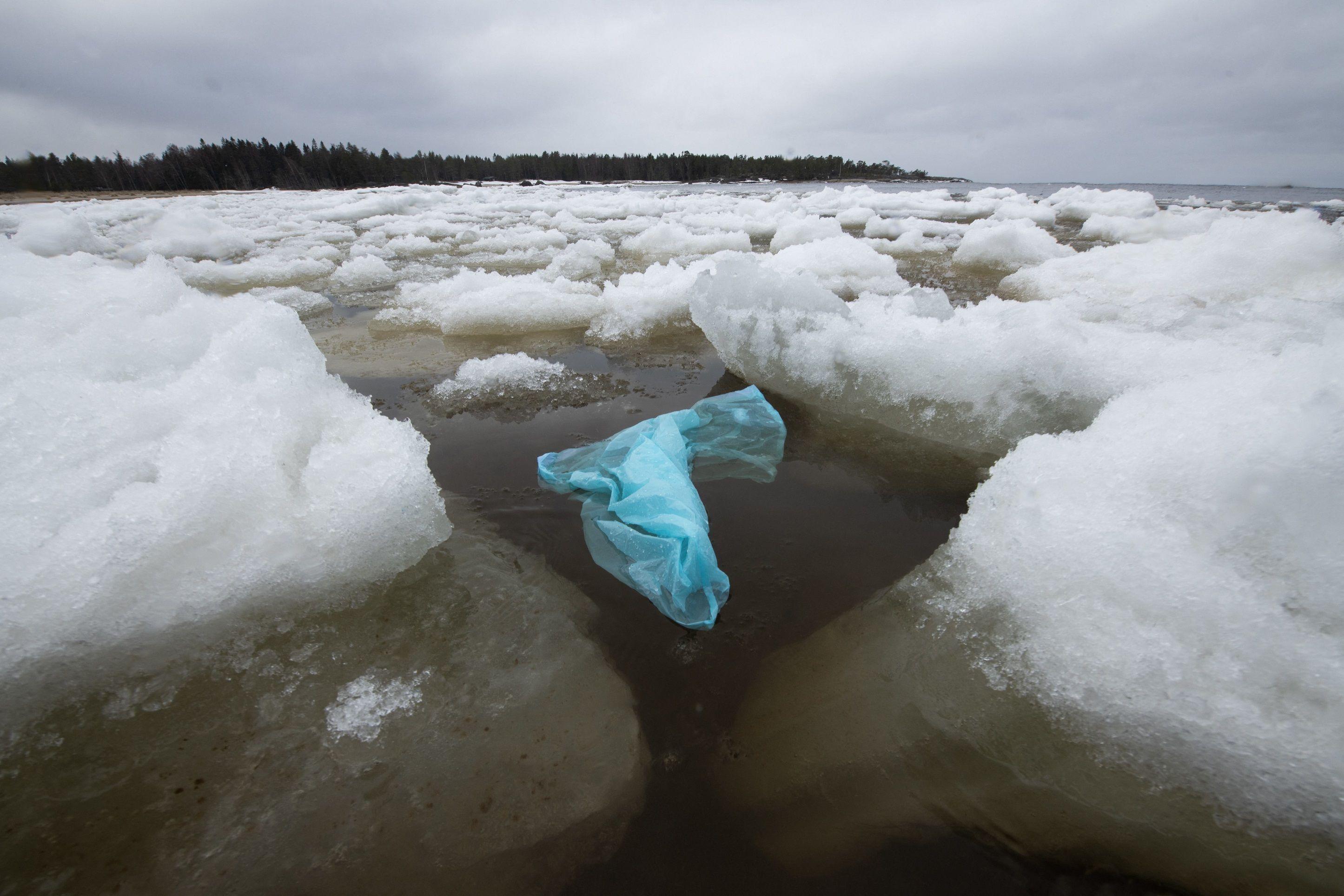 Plava plastična kesa u moru okružena santama leda