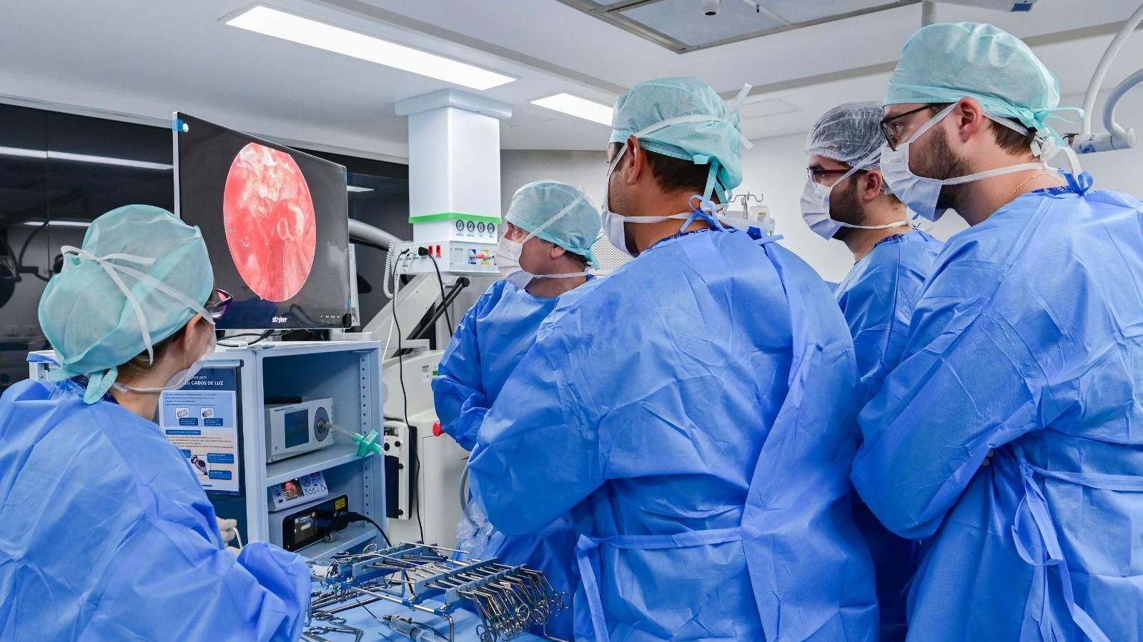 M&eacute;dicos olham para uma tela enquanto fazem uma cirurgia