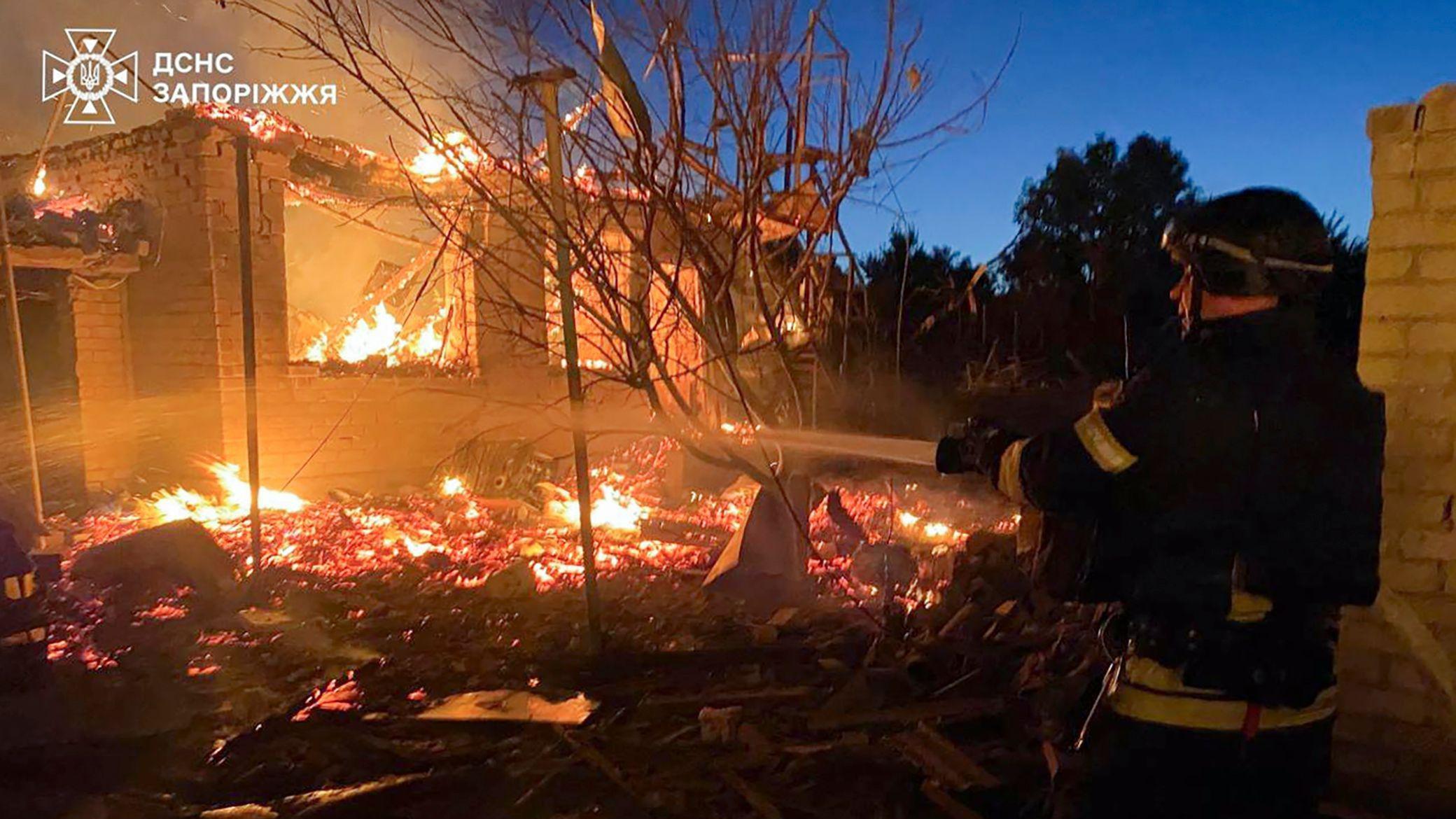 رجل إطفاء يعمل على إخماد حريق في موقع في زابوريجيا تعرض لضربة روسية ليلاً