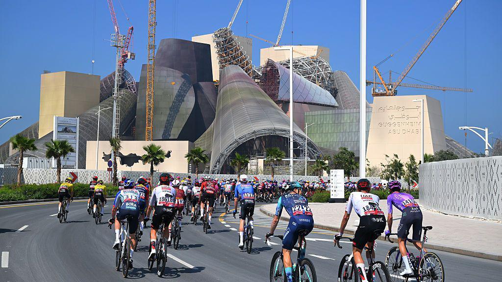 Un grupo de ciclistas pasa frente a un museo de arquitectura moderna en Abu Dabi