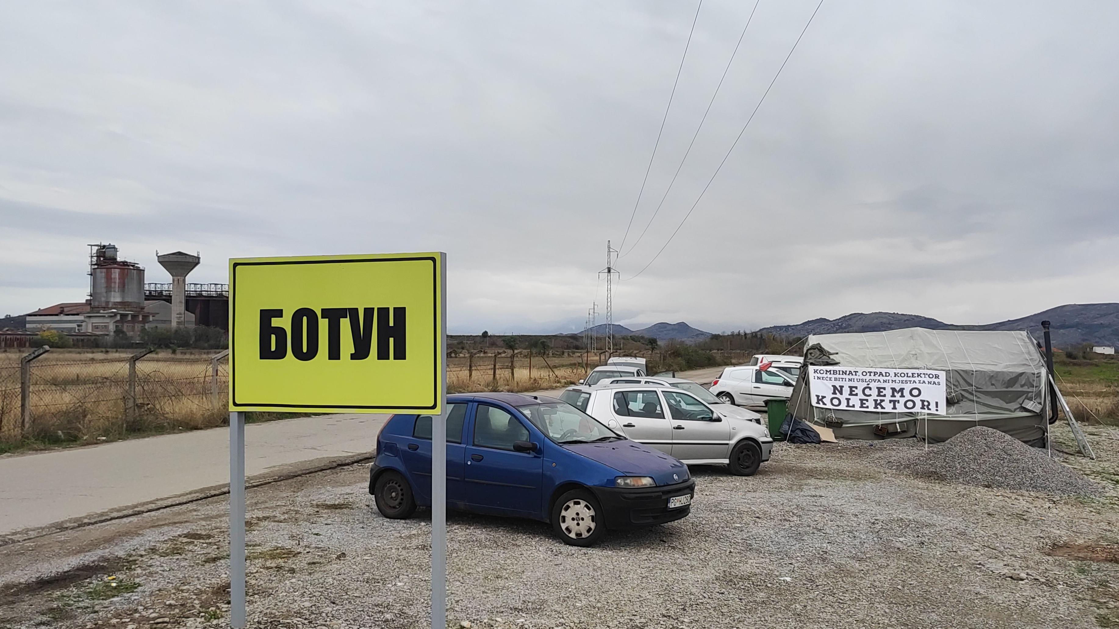 Kolektor otpadnih voda kao glavno političko pitanje u Crnoj Gori 4 Botun tabla, u pozadini nekadašnji kombinat i šator demonstranata